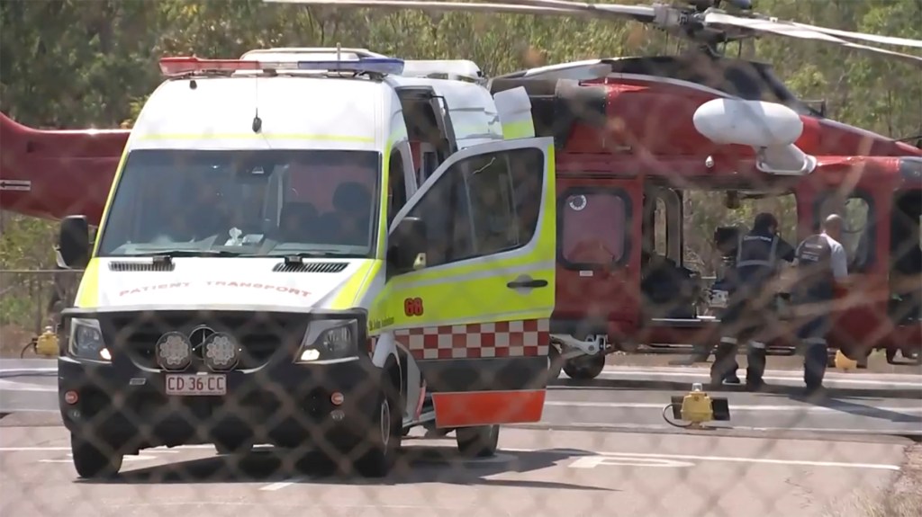 An ambulance sits parked in front of a helicopter used during the rescue mission of the downed Marine helicopter.