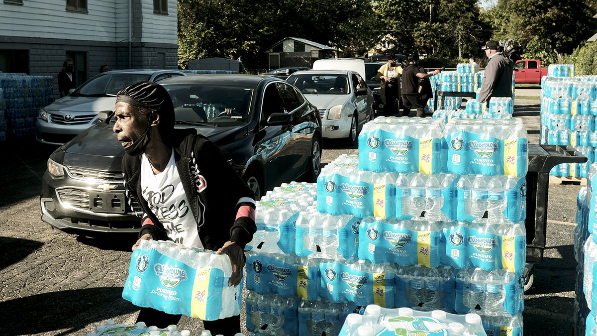 man distributes bottled water on street