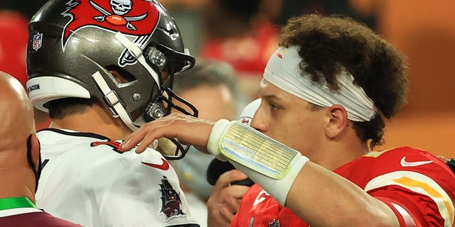 Tom Brady and Patrick Mahomes hug after a game