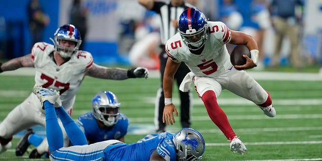 Giants player jumps over a Lions player