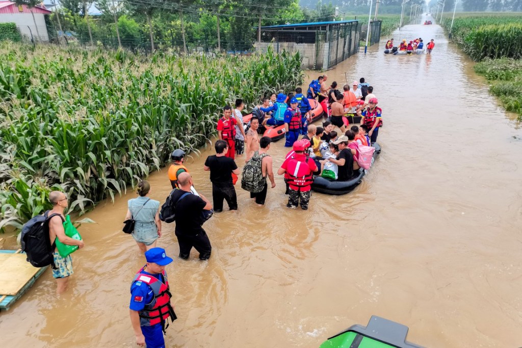 Rescue teams are seen evacuating people trapped in Diao Town. 
