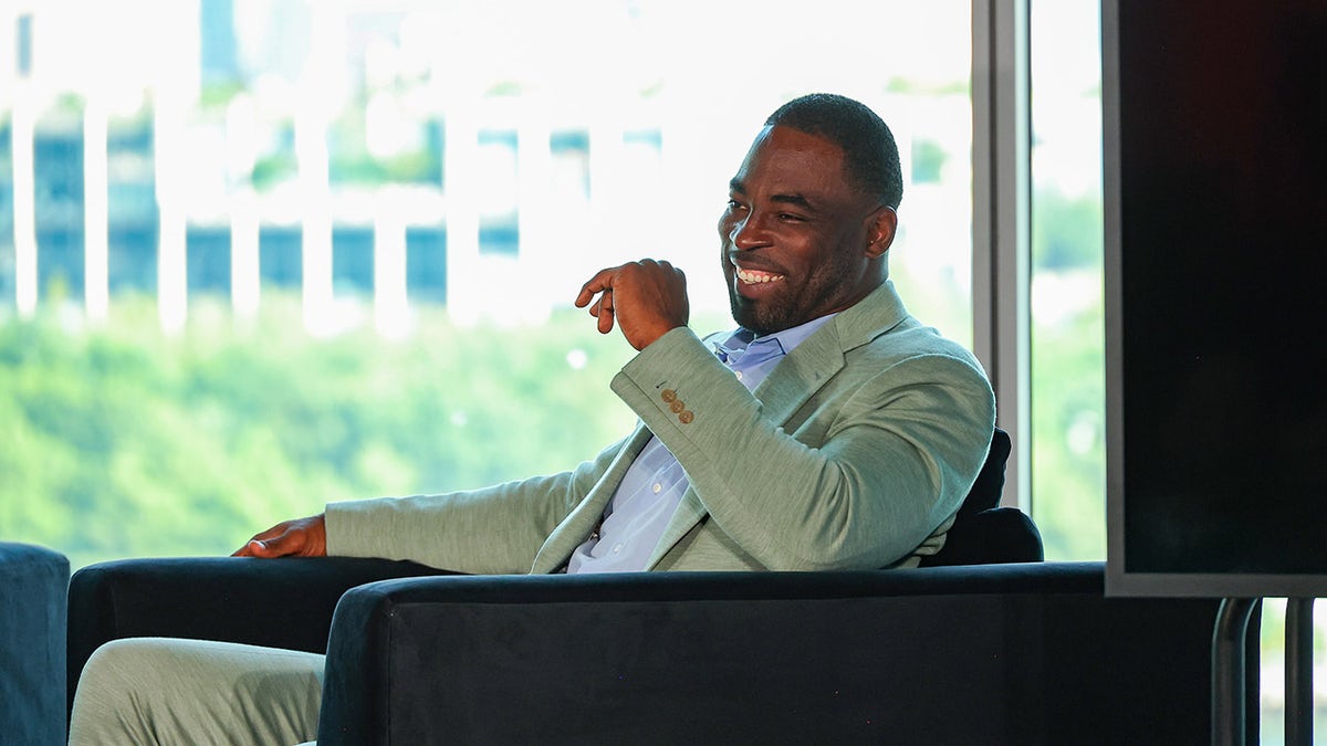 Justin Tuck smiles on chair