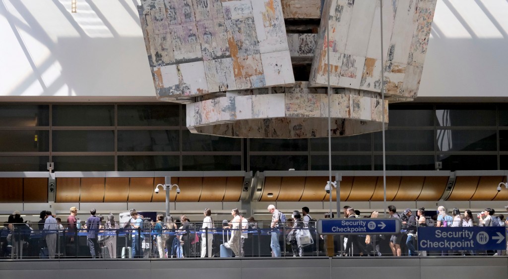 Travelers stand in line at the Tom Bradley International Terminal at LAX on Aug. 30, 2023. 