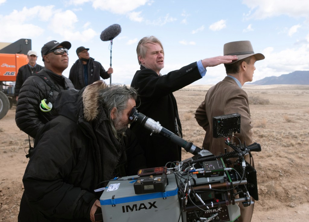 Director Christopher Nolan, center, and Cillian Murphy as J. Robert Oppenheimer, right, on the set of "Oppenheimer."