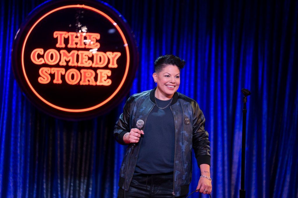 Sara Ramirez onstage doing  stand uo comedy in "And Just Like That." 