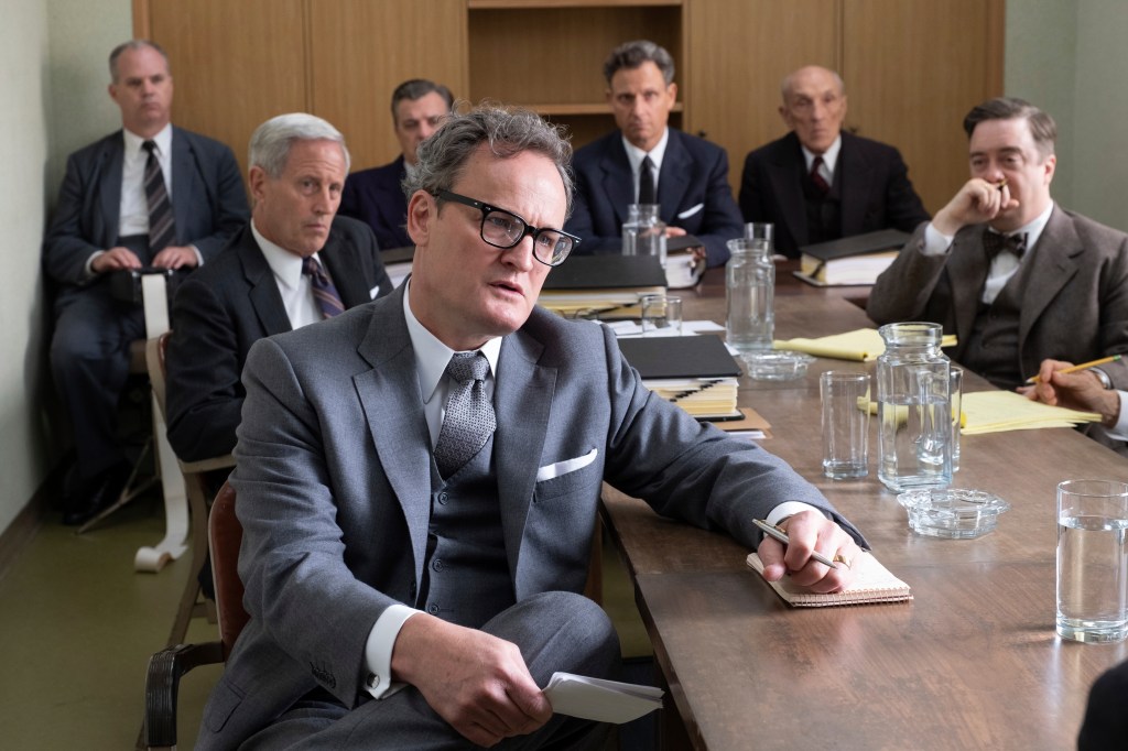 Jason Clarke sitting at a conference table looking serious. 