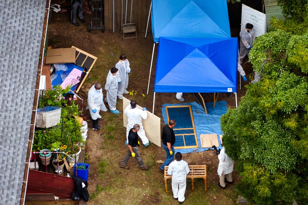 Crime scene investigators collect and document evidence from a shed in the back yard of the home of Gilgo Beach murders suspect.