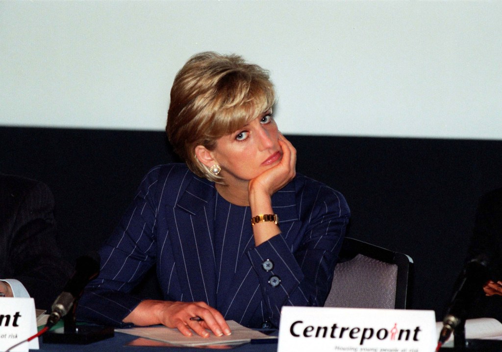 Princess Diana with her chin in her hands, looking unhappy. 