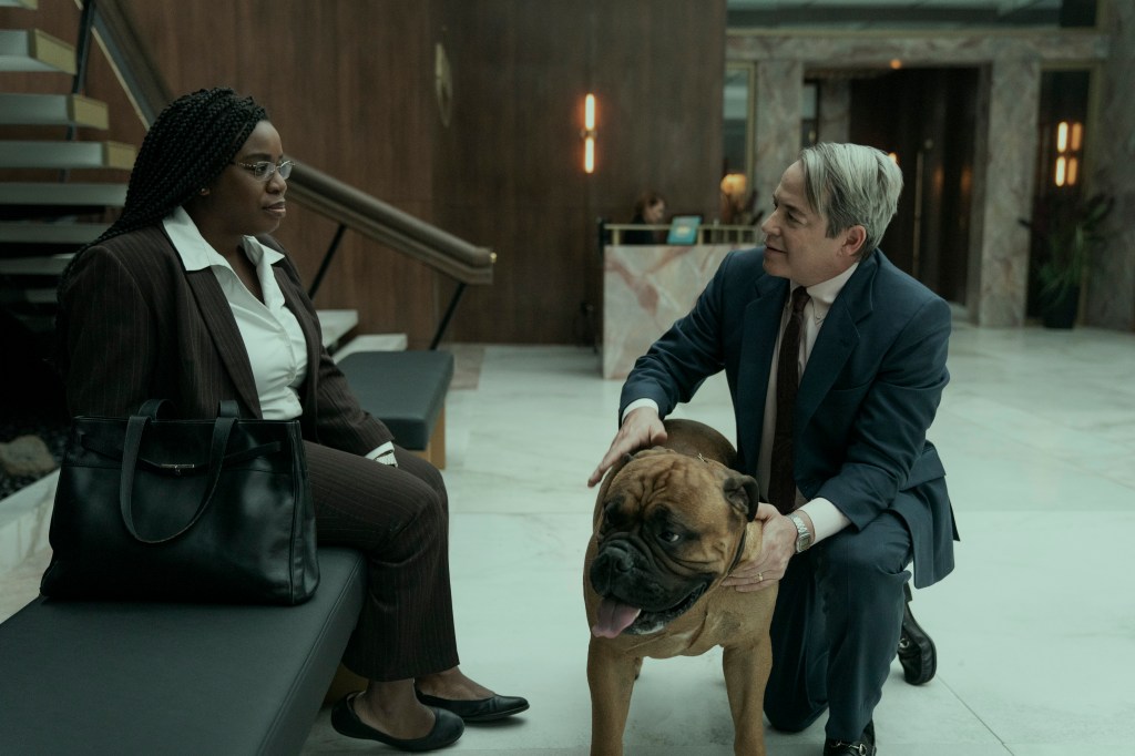 Uzo Aduba sitting on a bench while Matthew Broderick crouches in front of her petting a dog. 