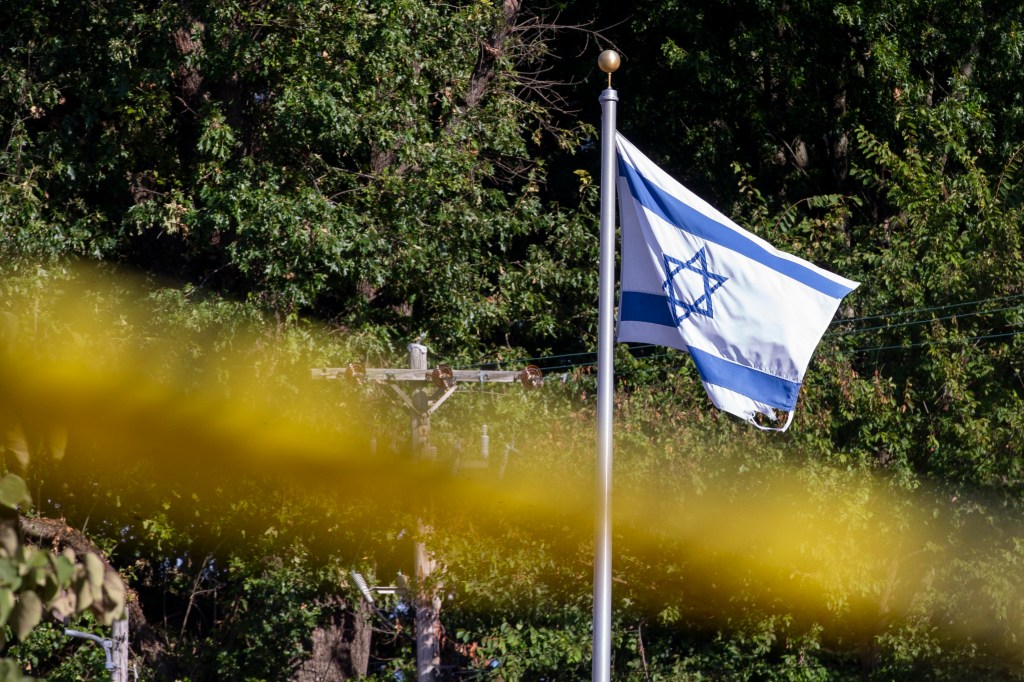 The flag of Israel flutters in the wind above crime scene tape outside Margolin Hebrew Academy-Feinstone Yeshiva of the South after a man attempted to enter the Jewish school with a gun.