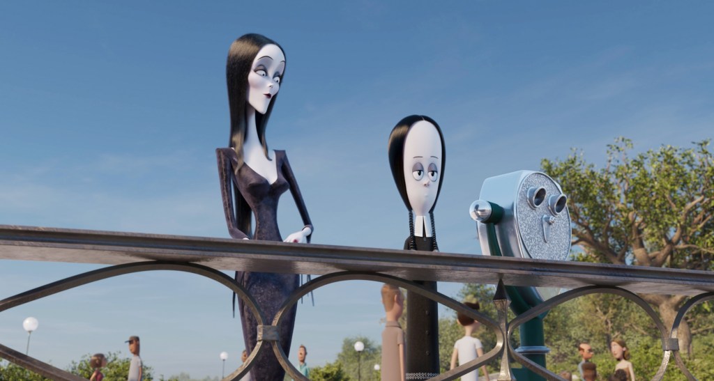 Morticia and Wednesday Addams stand on a viewing platform and look out, with Morticia looking at Wednesday rather than the view. 