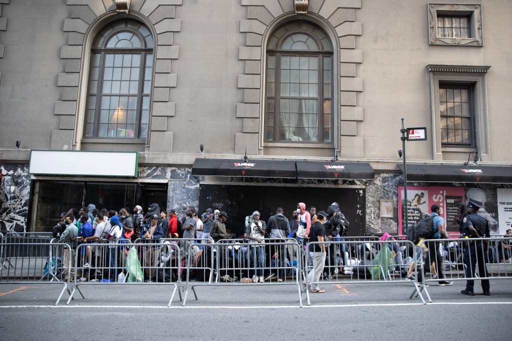 Migrants are seen outside the Roosevelt Hotel.