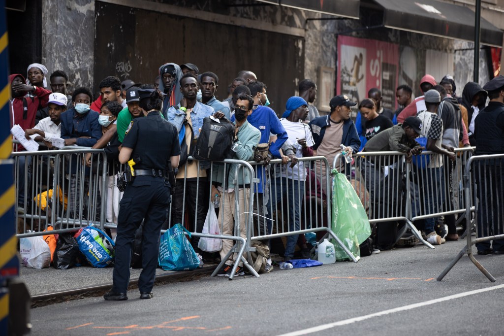 Migrants spill out from the Roosevelt Hotel on Tuesday.