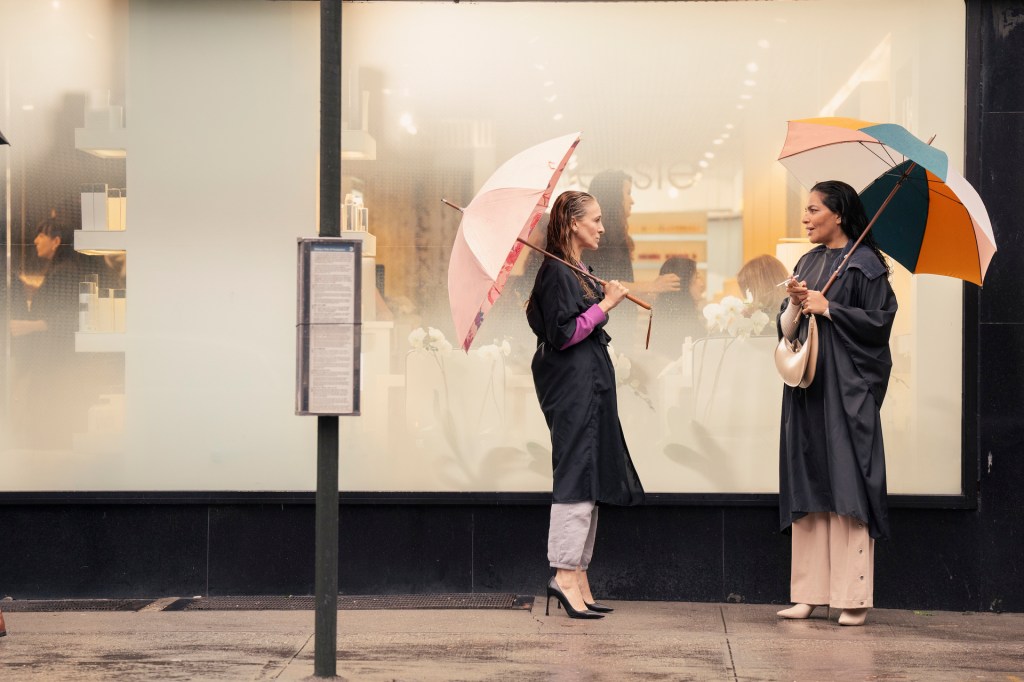 Seema and Carrie stand in the rain.