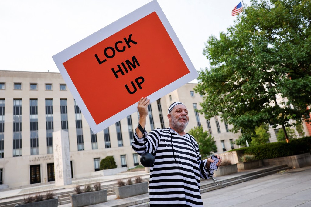 Domenic Santana of Miami holds a sign that reads "Lock Him Up" in front of the E. Barrett Prettyman Federal Courthouse ahead of Donald Trump's arraignment