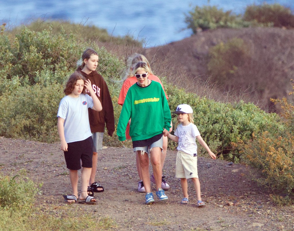 Spelling walking with four of her children in a scenic area. 