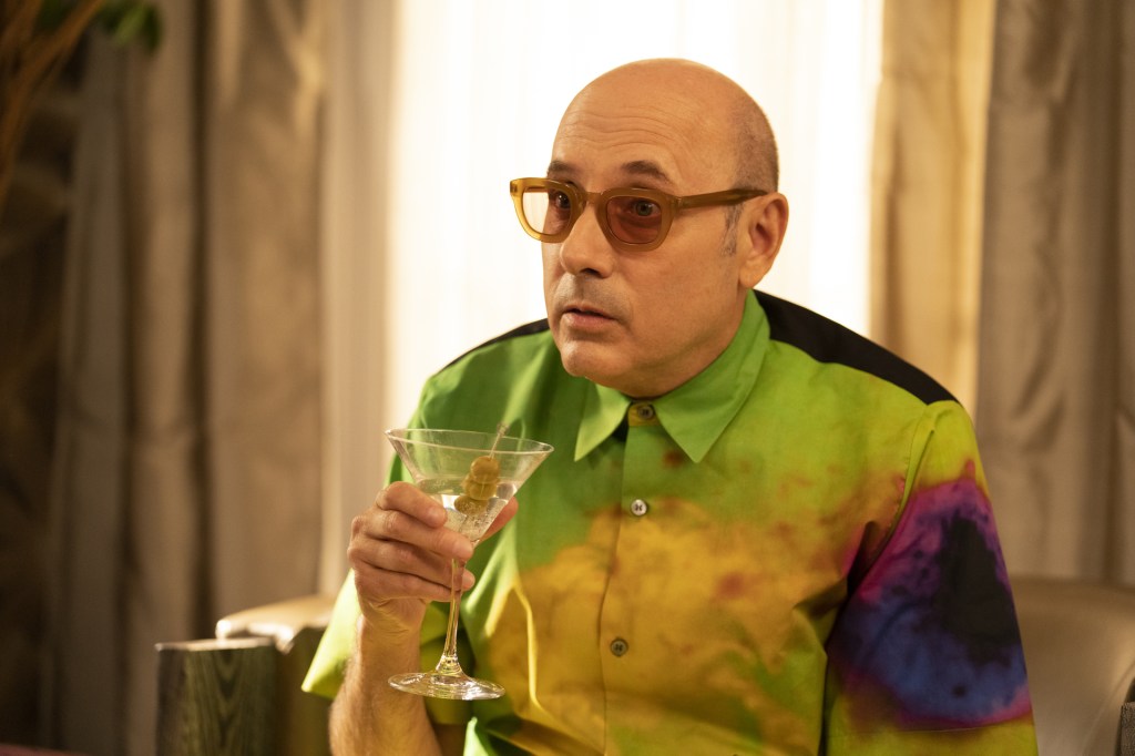 Photo of Willie Garson wearing a tye-dye shirt and holding a martini. 