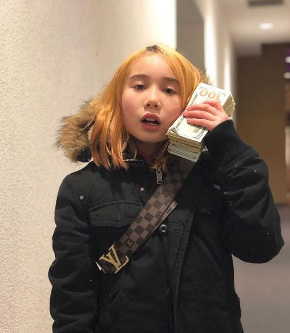 Photo of Lil Tay with a stack of cash. 