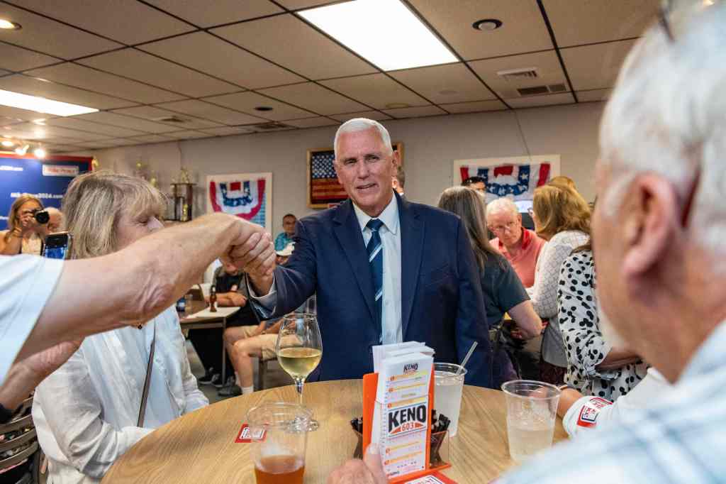 US Presidential hopeful and former Vice President Mike Pence greets people as he arrives at a campaign event at American Legion Hall Post 27 in Londonderry, New Hampshire, on August 4.