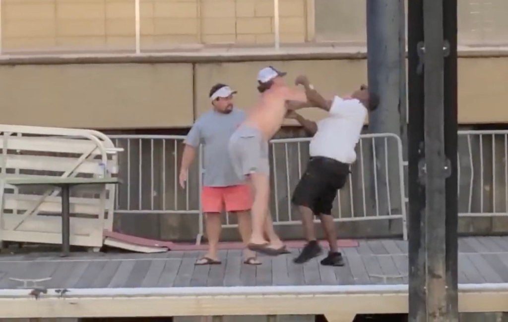 After a heated argument, the security guard was rushed by a shirtless man, leading to the wild brawl. 
