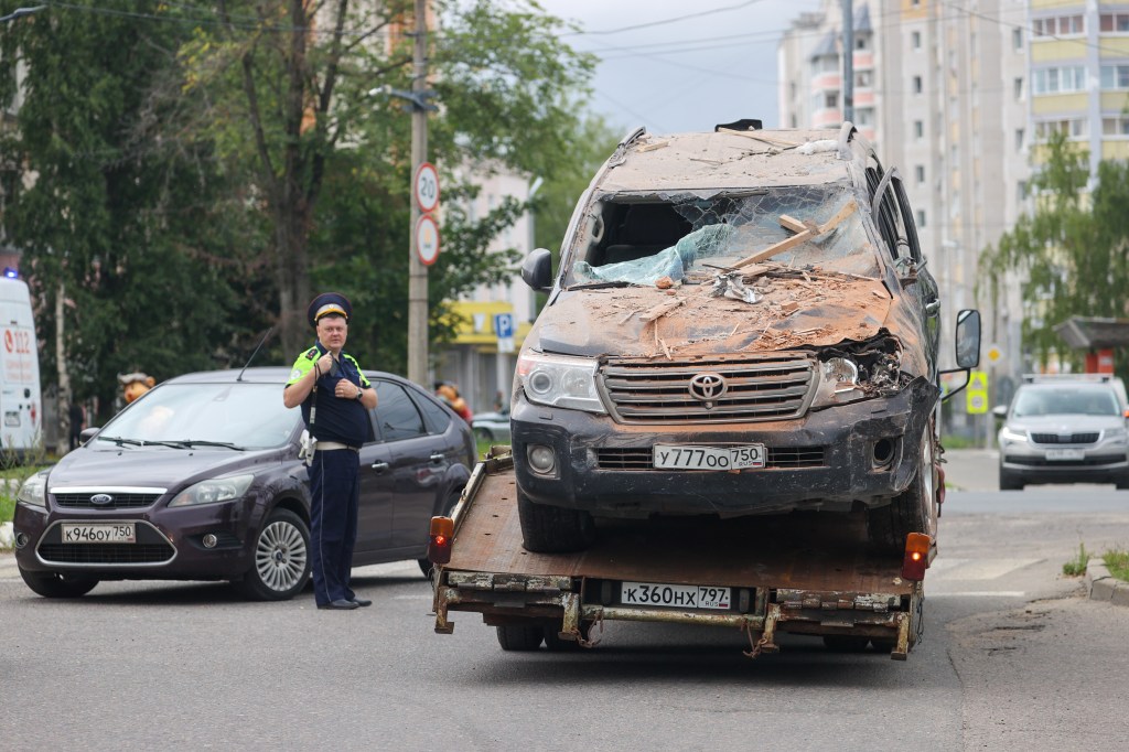 A car wreckage is being removed from the site of the blast in Sergiev Posad, Russia