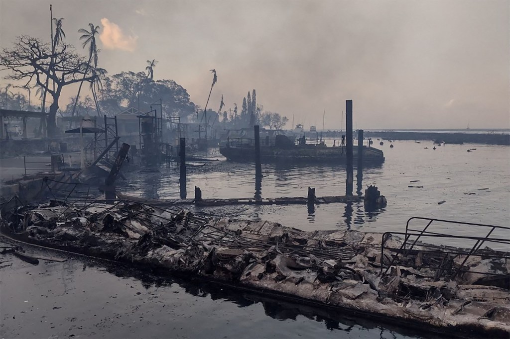 A charred boat lies in the scorched waterfront after wildfires fanned by the winds of a distant hurricane devastated Maui's city of Lahaina.