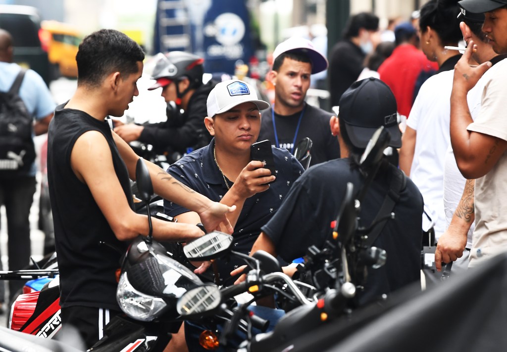 Migrants at New York City's Roosevelt Hotel spill out onto the streets as they number too many to be housed inside.