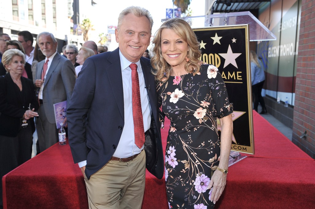 Photo of Pat Sajak and Vanna White on a red carpet. 