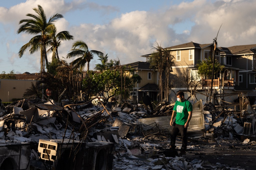 A Mercy Worldwide volunteer makes a damage assessment of a charred apartment complex in the aftermath of a wildfire in Lahaina on Saturday.