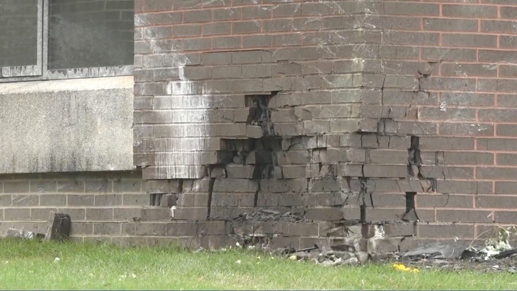 The damage to the side of the building after the crash.