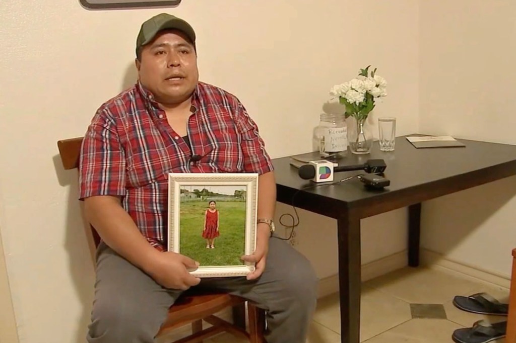 Carmelo Gonzalez holding a portrait of his dead daughter