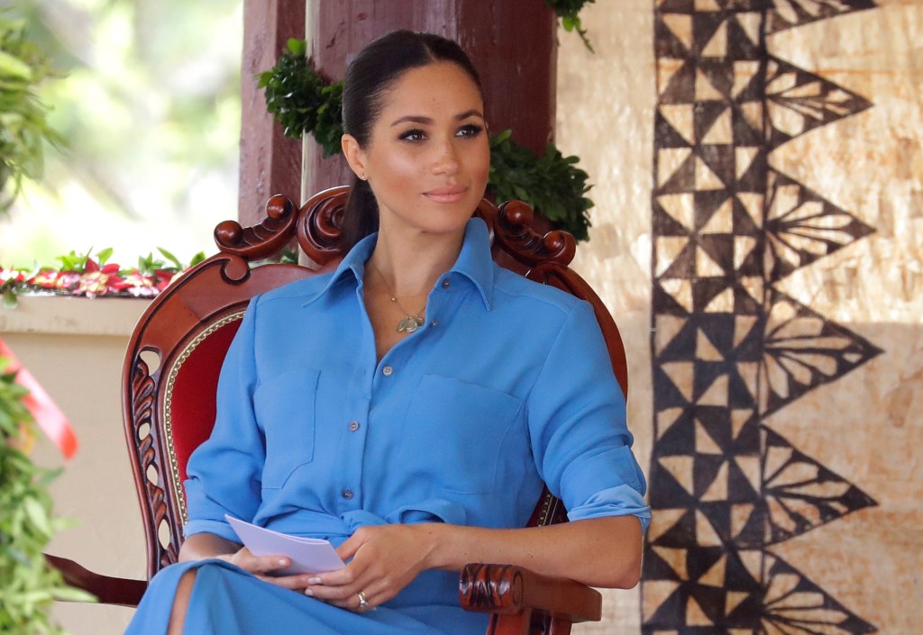 Photo of Meghan Markle wearing a blue button-down shirt. 