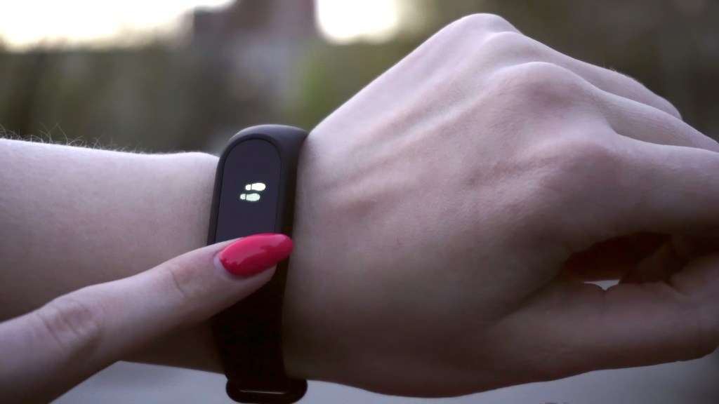 Young woman using wearable fitness tracker