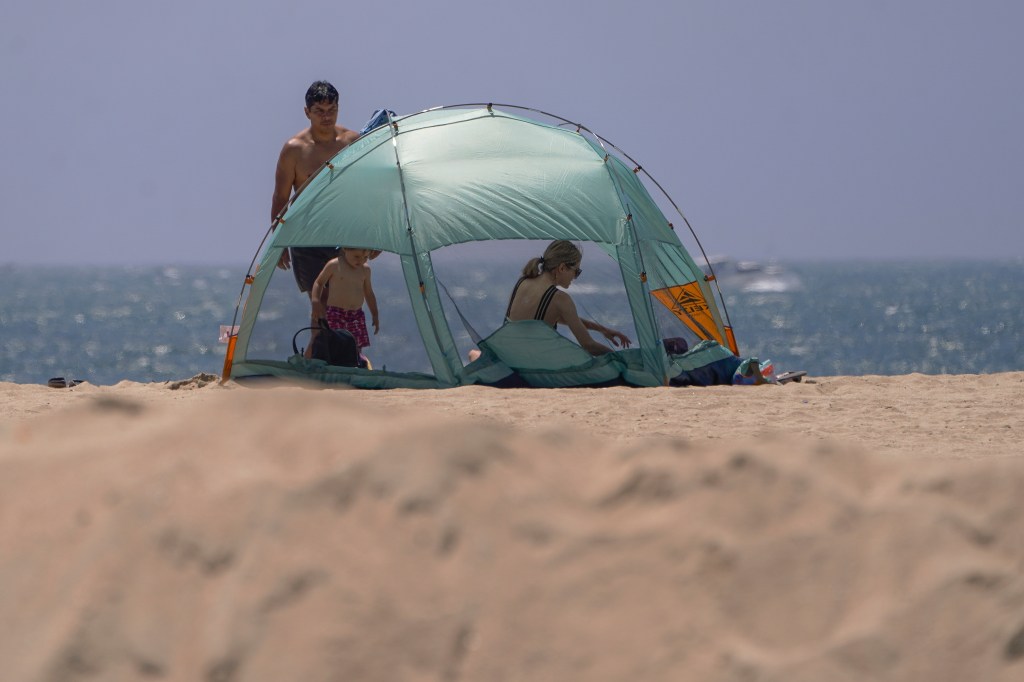 California beach goers on Friday ahead of tropical storm on the way. A family hangs out around a tent on the beach.