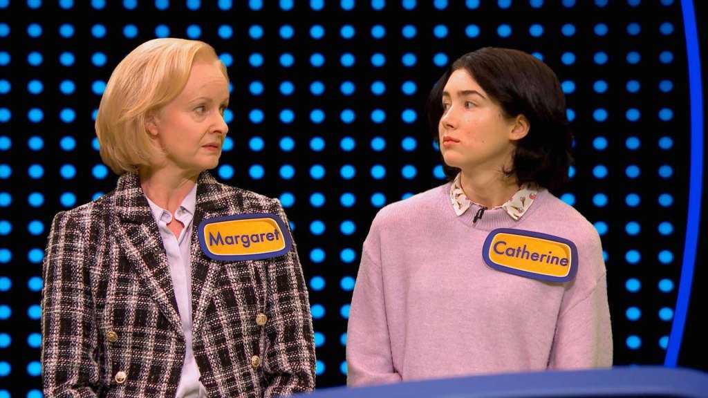 Margaret and her surly daughter Catherine on the game show "3X3." They're facing each other with nasty looks in their eyes. Margaret is wearing a business suit and Catherine a pink sweater. They're both wearing nametags.