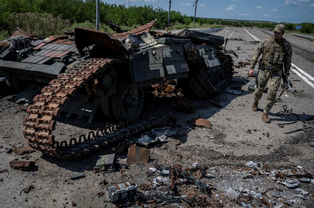 A Ukrainian serviceman walks near a destroyed Ukrainian tank, as Russia's attack on Ukraine continues, near the village of Robotyne.