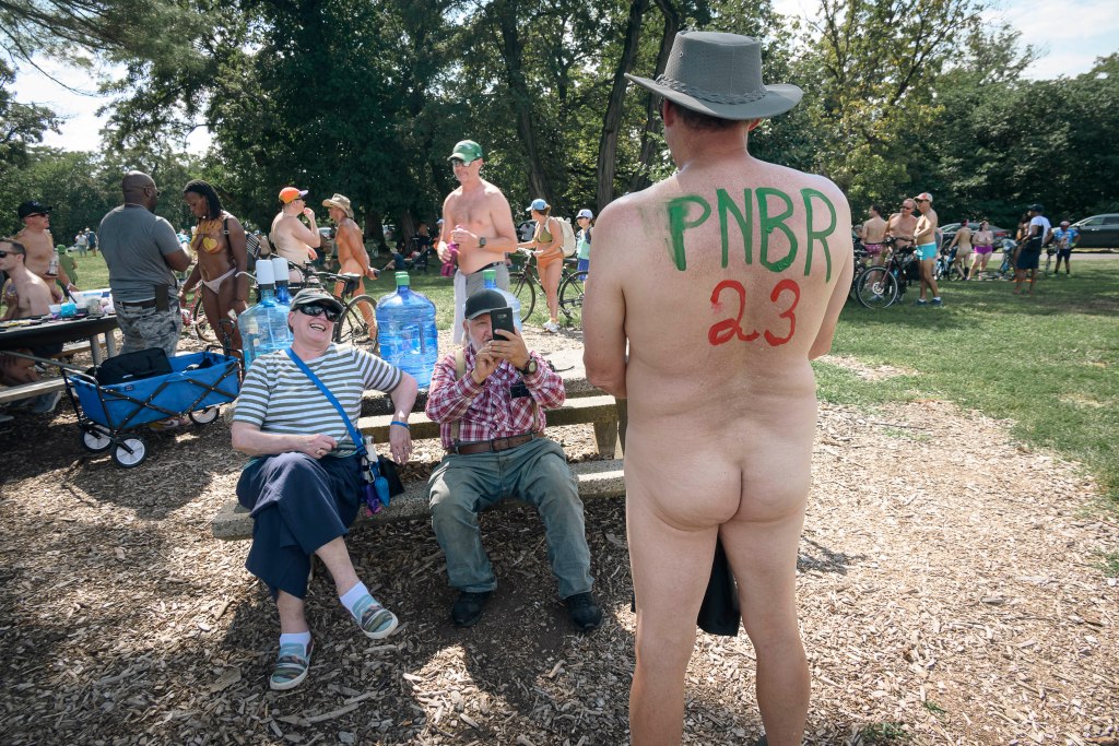 nude bicyclist poses for photos. 
