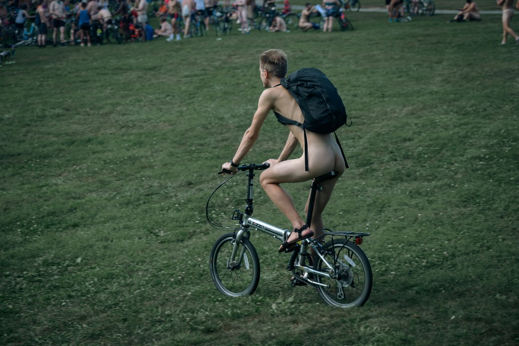 a naked biker -- save for his packpack -- is pictured
