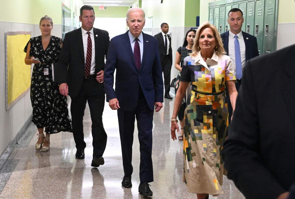 US President Joe Biden and US First Lady Jill Biden walk through the hallway of Eliot-Hine Middle Schoo.