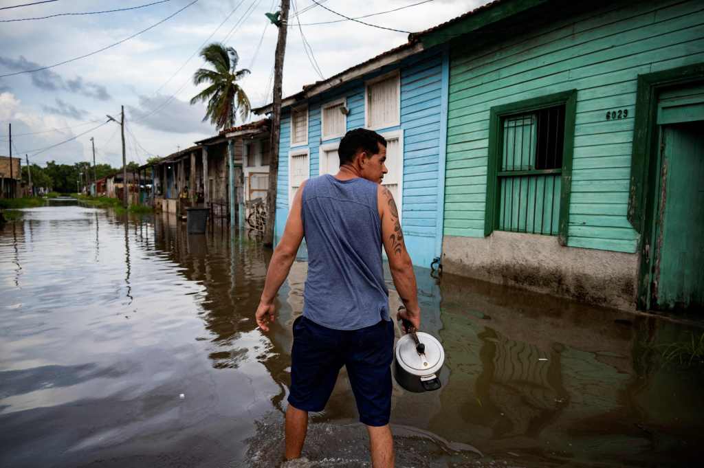 A man walks in a flooded area of Batabano, Mayabeque Province, Cuba, on August 28, 2023, as Tropical Storm Idalia approaches the western tip of the island nation.