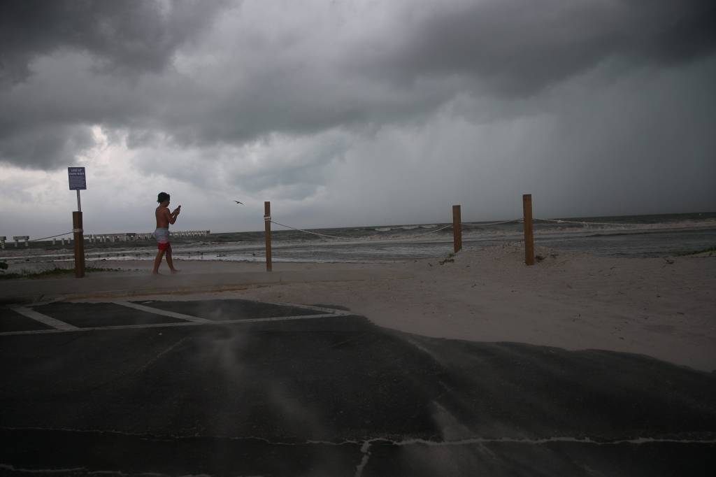 Beachgoers check out the surf as Hurricane Idalia approaches Florida.
