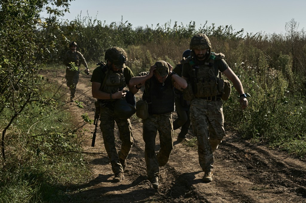 Ukrainian servicemen help to evacuate a wounded soldier at the front line near Bakhmut, Donetsk region, Ukraine, Wednesday, Aug. 30, 2023.