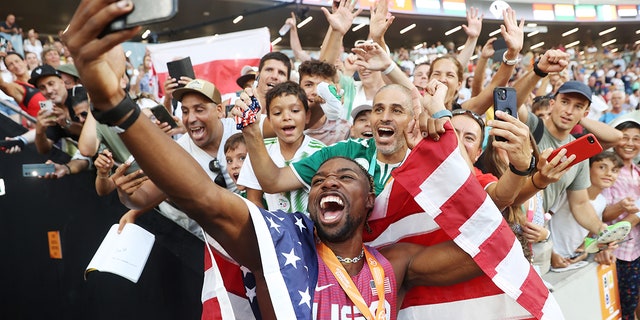 Noah Lyles takes selfie with fans