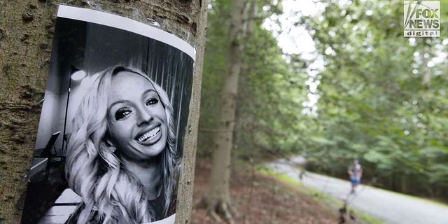 A photo of Rachel Morin is posted on a tree along a hiking route