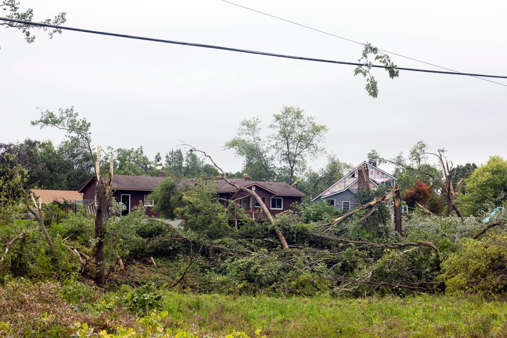 A damaged power line is seen hanging over debris on the ground following tornadoes which wrecked havoc in Michigan.