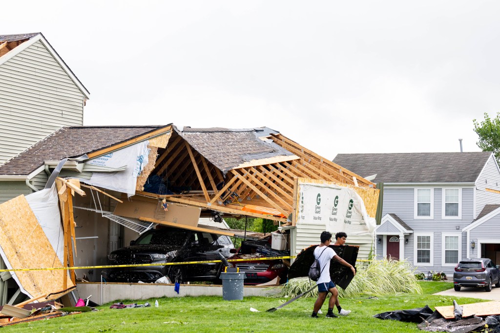 Comstock Park football players help move debris in a subdivision off of Pine Island Road in Kent County, Mich. on Friday, Aug. 25, 2023. 