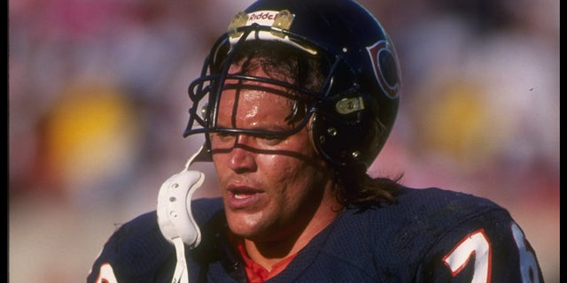 Steve McMichael walks with helmet on head