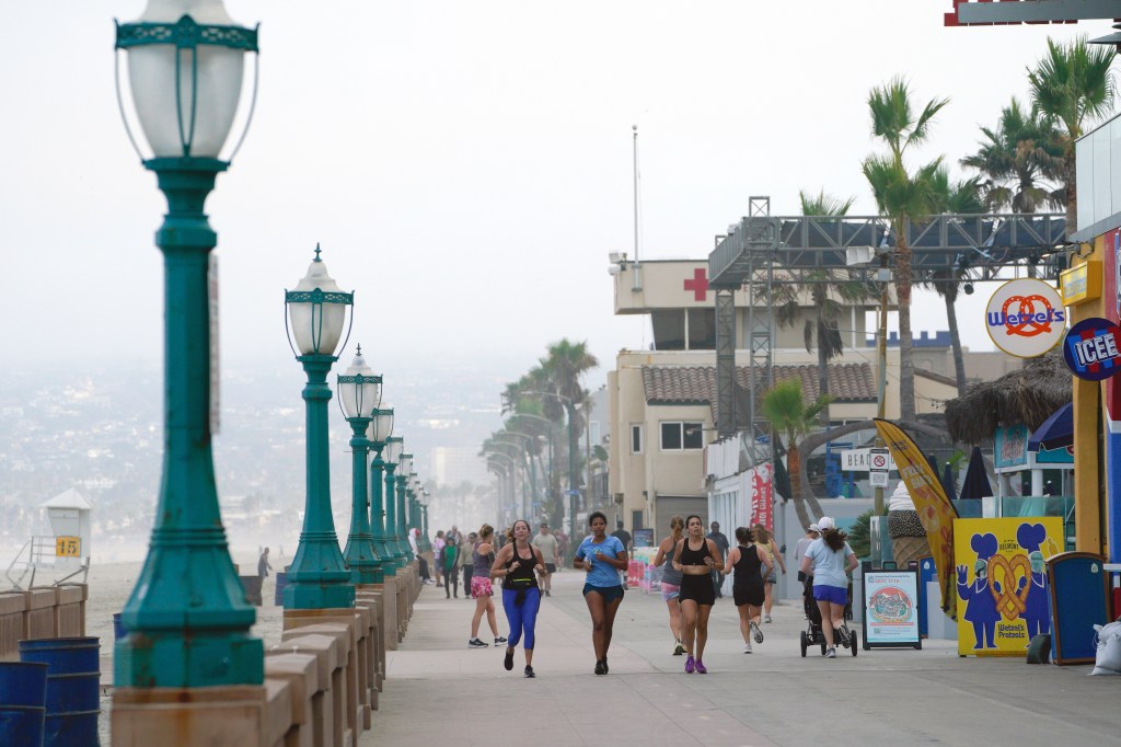 People run on a boardwalk in San Diego as the California region prepares for Hurricane Hillary.