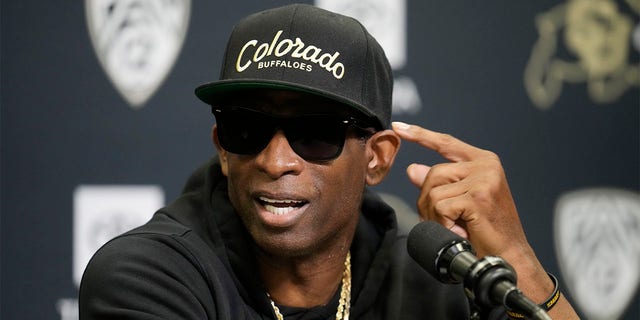 Deion Sanders speaks with reporters