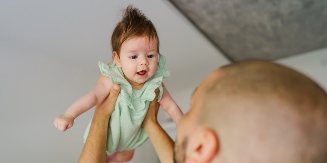 Father throwing baby